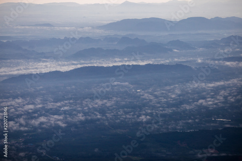 Background, high angle from the passenger plane. You can see the scenery by the distance (mountains, rivers, sky, fog, houses), the photos may be blurred during the flight.