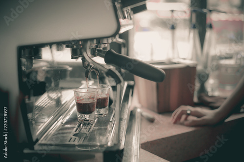 Espresso shot from coffee machine in coffee shop.