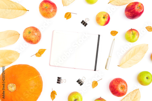 Thanksgiving day. Autumn composition of fall leaves, apple fruit and pumpkin with notebook, pen and clips on white background. Flat lay, top view