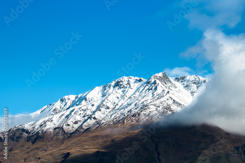 Stunning of the scenery of rocky mountain covered with snow after the raining day. Cloudy and foggy. Diamond lake track, Wanaka, New Zealand. photo