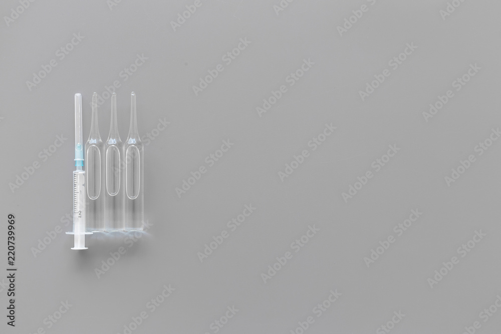 Flu vaccination concept. Syringe and ampoulie on grey background top view space for text Flu vaccination concept. Syringe and ampoulie on grey background top view space for text