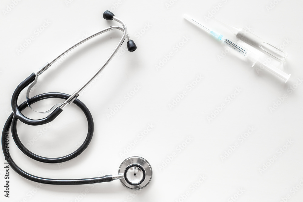 Infuenza vaccine in syringe near stethoscope on white background top view copy space Infuenza vaccine in syringe near stethoscope on white background top view copy space