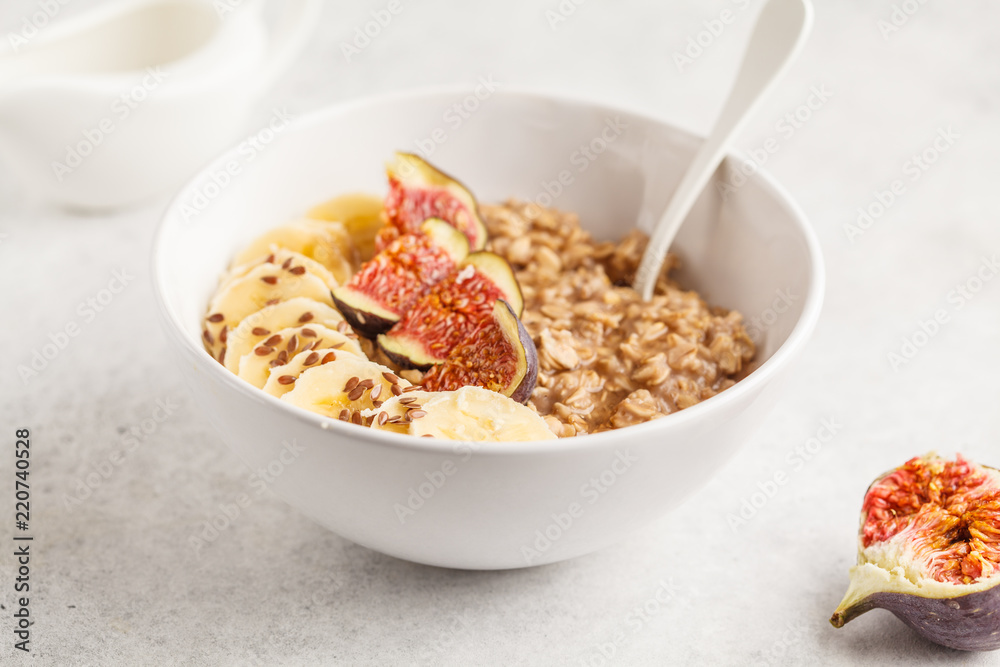 Oatmeal with banana, fig and flax seed. White background Oatmeal with banana, fig and flax seed. White background