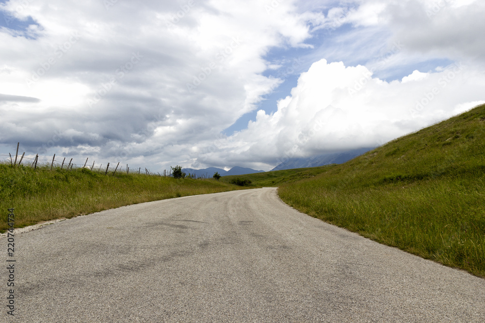 view of mountain road and clouds