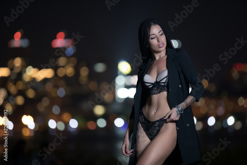 Sexy woman showing her body under dress at night city