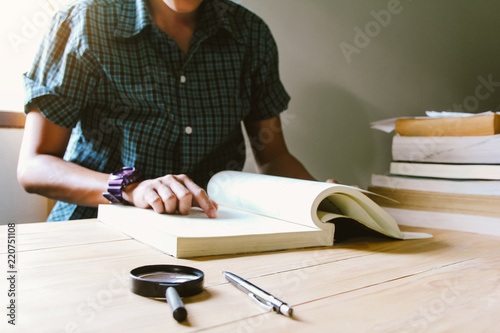 Blur. Man in green plaid shirt.Sitting on wood chair, reading book . sunset  and instagram style filter photo vintage tone,Selective Focustone.Selective Focus photo