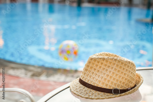 Straw hat on the sun lounger by pool. poolside rest and relaxation in tourist trip