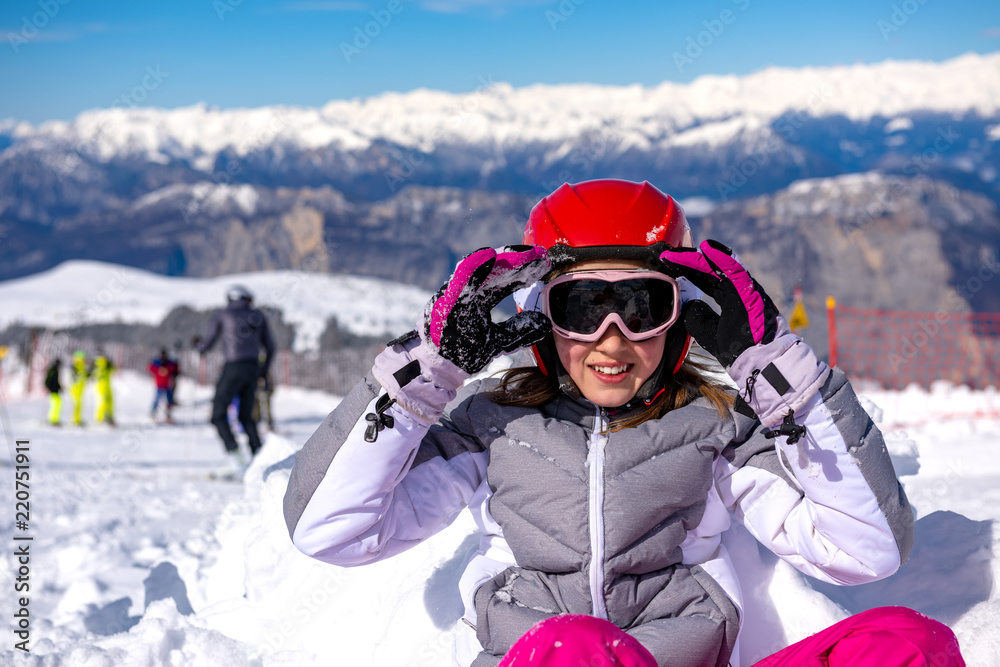 happy little girl arranges ski goggles
