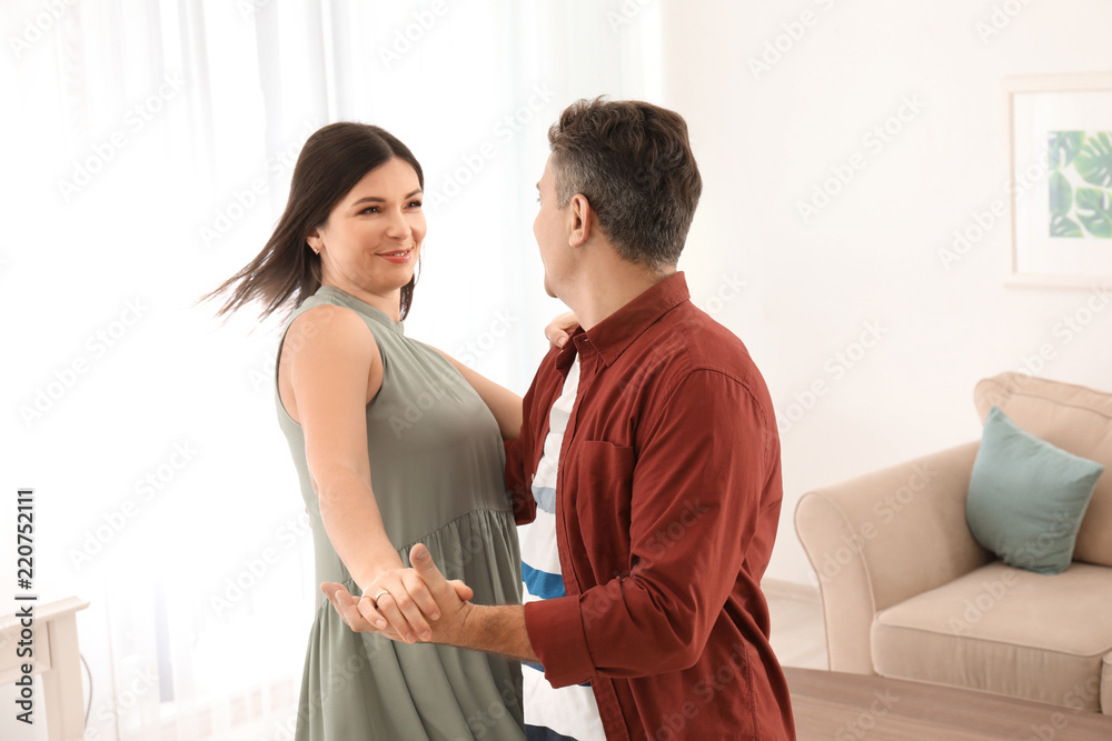Fototapeta premium Lovely couple dancing together at home