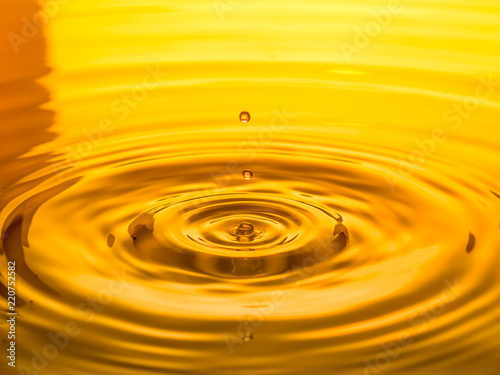 close up of a drop oil on a yellow background
