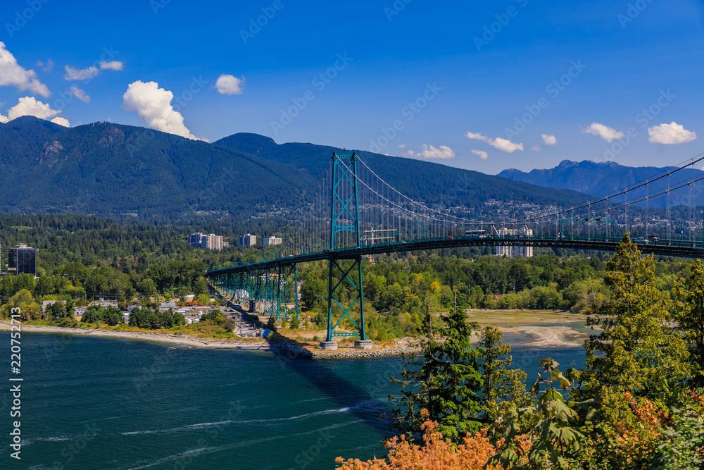 Fototapeta premium Lions Gate lub First Narrows Bridge w Stanley Park Vancouver w Kanadzie z North Vancouver i górami w tle