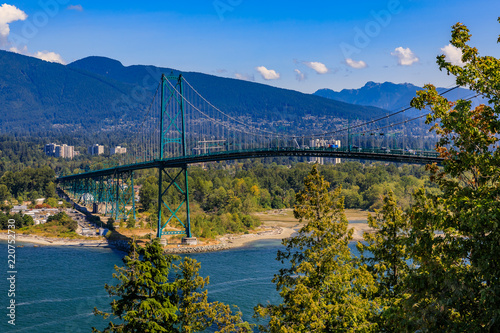 Lions Gate or First Narrows Bridge in Stanley Park Vancouver Canada with North Vancouver and mountains in the background photo