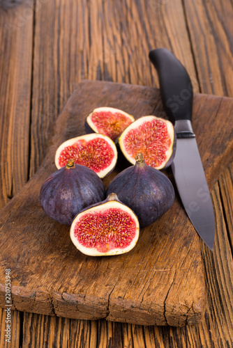 Fototapeta Naklejka Na Ścianę i Meble -  Group of whole and sliced ripe, delicious and sweets figs on a old rustic wooden cutting board