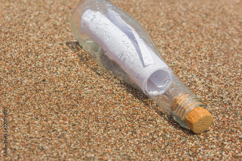 A message in a bottle on the sand. note on salvation, please help