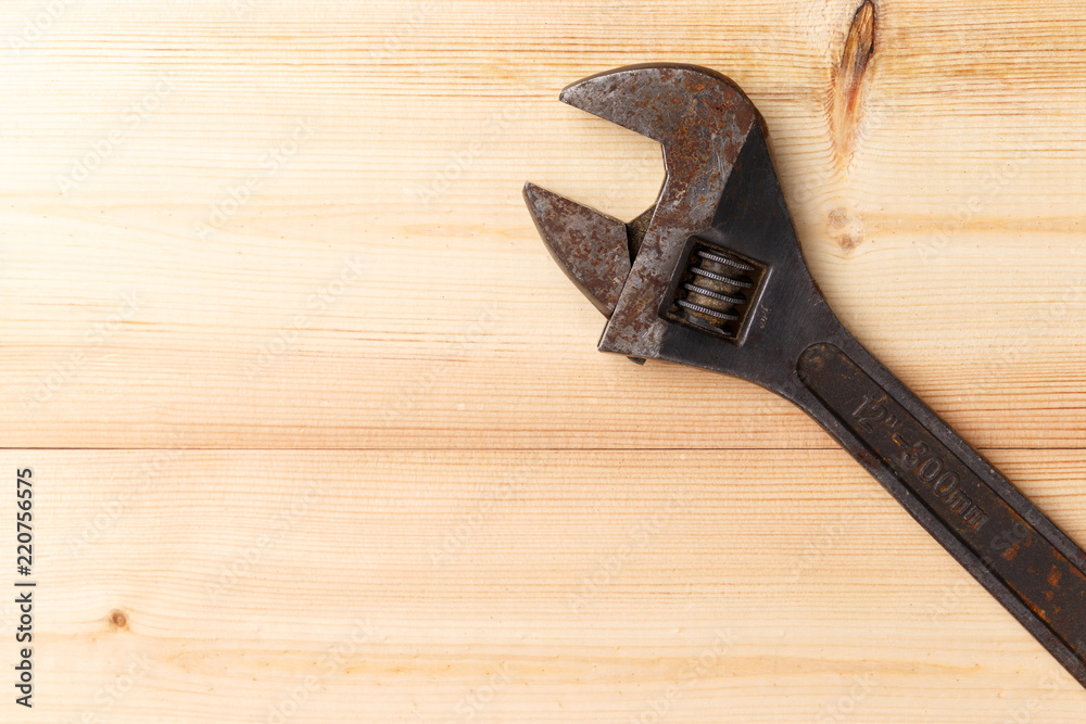 Old, rusty adjustable wrench on wooden background. Top view. Flat lay. Copy space. Close-up Old, rusty adjustable wrench on wooden background. Top view. Flat lay. Copy space. Close-up