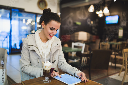 Attractive young woman using tablet in cafe