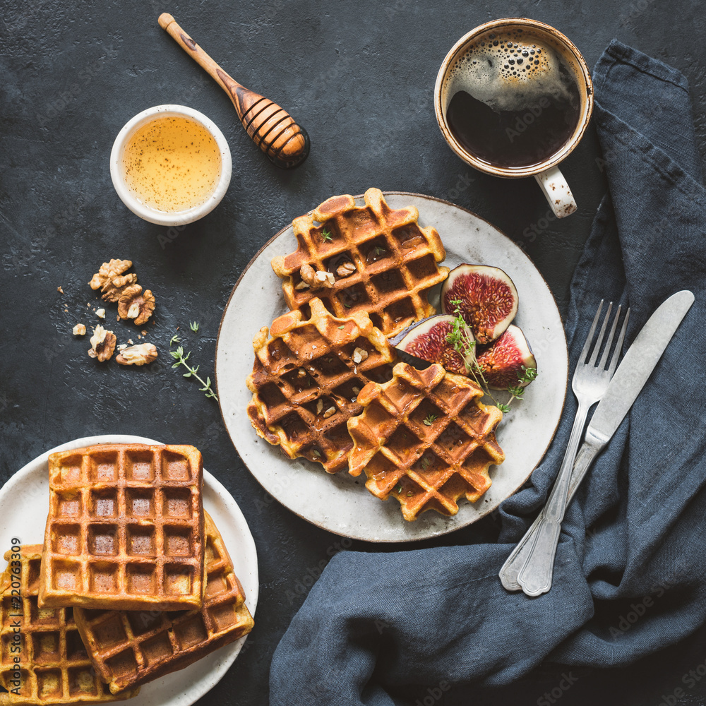 Belgian waffles with figs and honey for breakfast on black background. Top view. Square crop. Tasty breakfast with waffles, coffee and honey Belgian waffles with figs and honey for breakfast on black background. Top view. Square crop. Tasty breakfast with waffles, coffee and honey