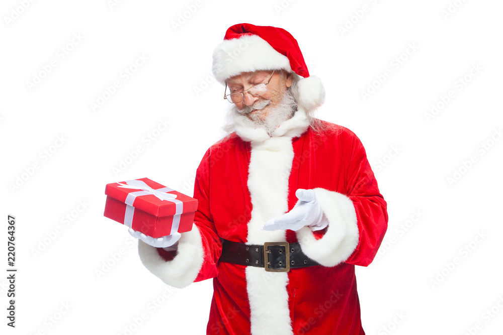 Christmas. Smiling Santa Claus in white gloves is holding a gift red box with a bow. Pointing at the gift. Isolated on white background. Christmas. Smiling Santa Claus in white gloves is holding a gift red box with a bow. Pointing at the gift. Isolated on white background.