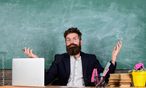 Teacher wondered low level of knowledge. What stupid thought. Man bearded teacher wondering expression sit classroom chalkboard background. What are you talking about. Unpleasant wonder photo