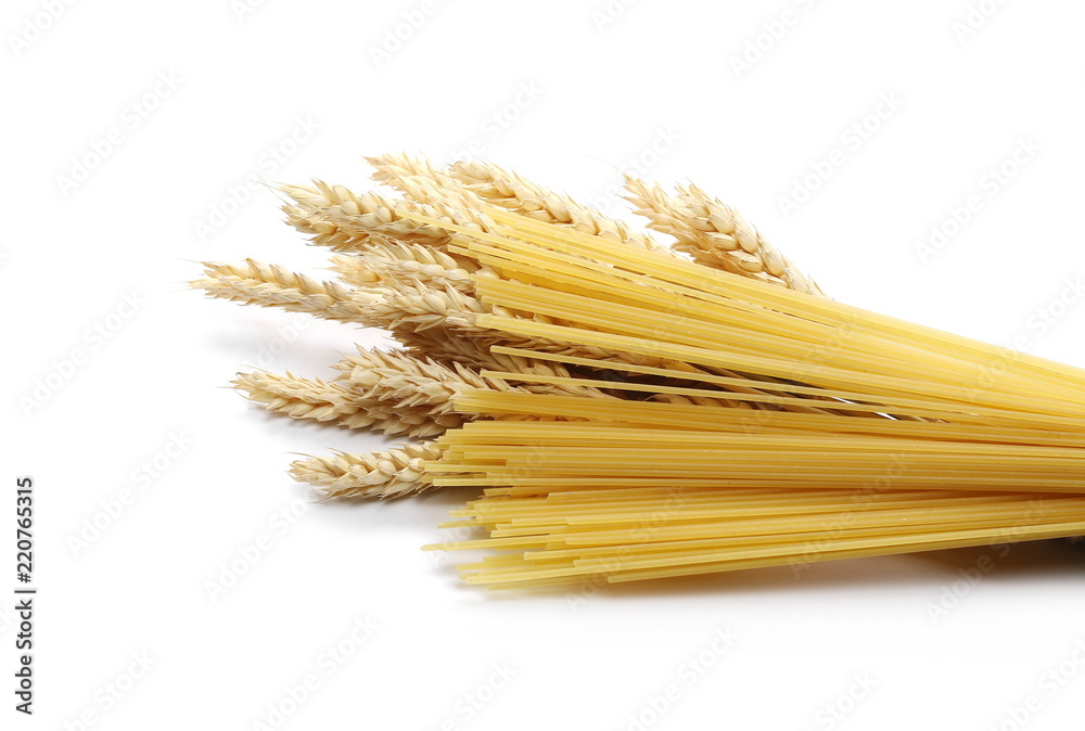 Dry wheat ears, grain with raw pasta noodles for spaghetti isolated on white background Dry wheat ears, grain with raw pasta noodles for spaghetti isolated on white background
