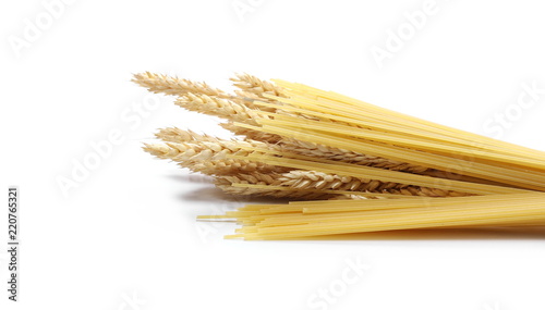 Dry wheat ears, grain with raw pasta noodles for spaghetti isolated on white background