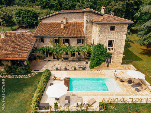 Obraz na płótnie aerial view of couple relaxing at swimming pool near villa in Italy