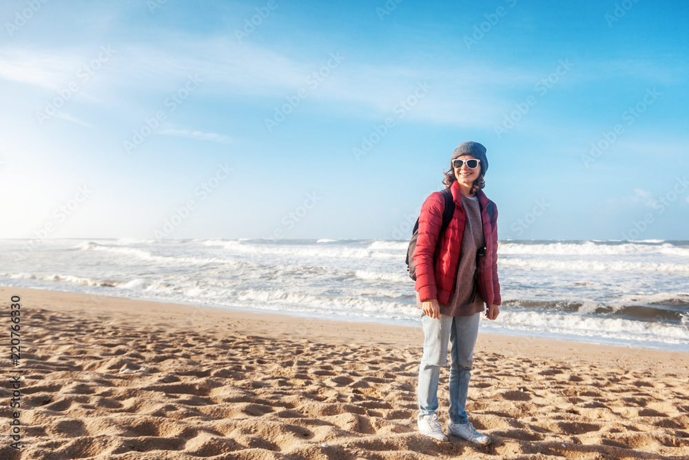 Young girl traveler walks along the Atlantic coast in Portugal in winter, happiness and freedom