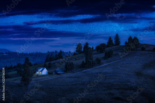 Lonely carpathian house on a mountain hill at night
