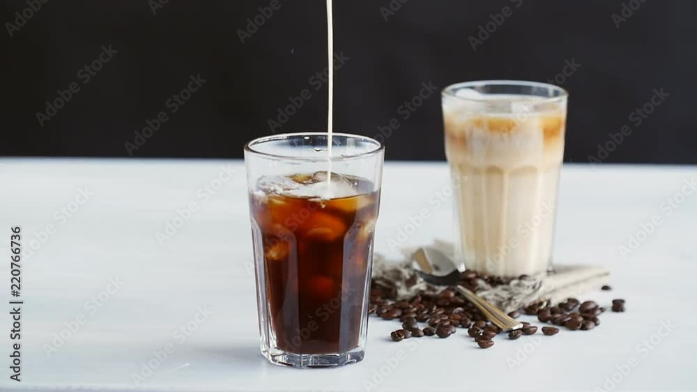 Concept of coffee and cocktails. Cream poured into coffee with ice Concept of coffee and cocktails. Cream poured into coffee with ice