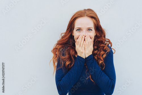 Embarrassed young woman covering her face photo