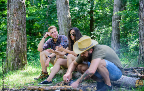 Company friends camping forest. Man brutal bearded hipster prepares bonfire in forest. Ultimate guide to bonfires. Arrange woods twigs or sticks. How build bonfire outdoors. Camping weekend leisure
