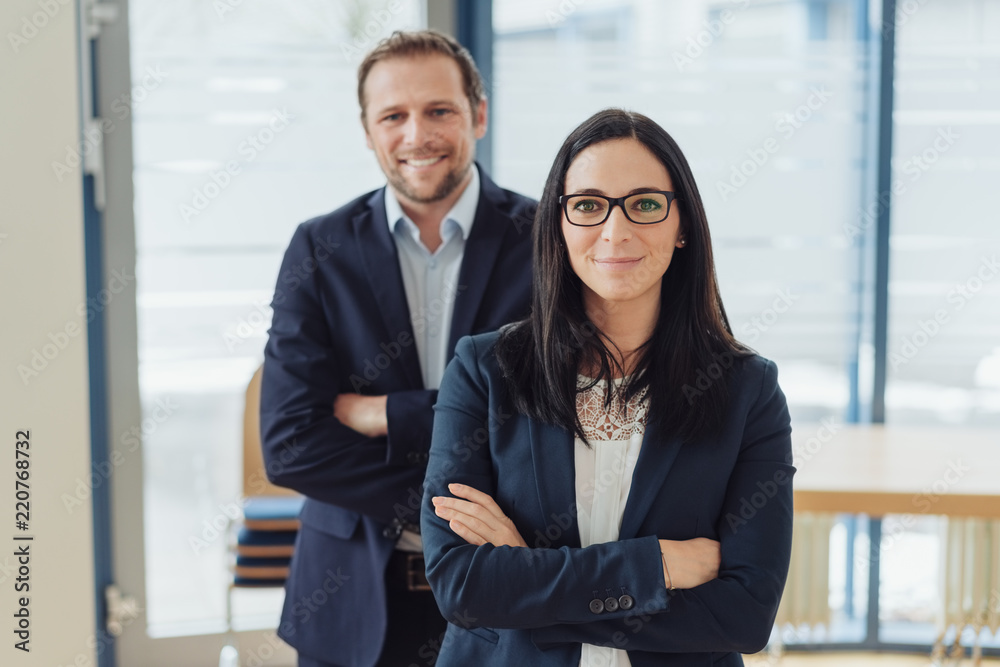 Cheerful businesswoman with man in background Cheerful businesswoman with man in background