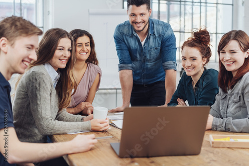 Happy successful business team looking at a laptop