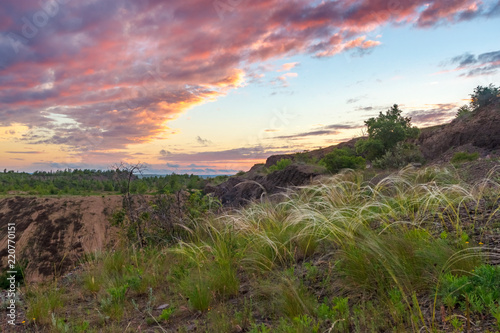 The beautiful sunset view of stony steppe with colorful cloudy sky and feather grass on foreground. Russia, Rostov-on-Don region