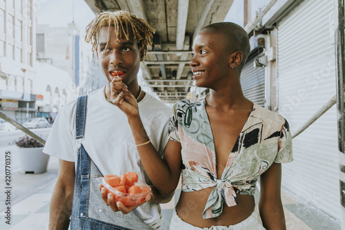 Fototapeta Couple snacking on fruit in the summer