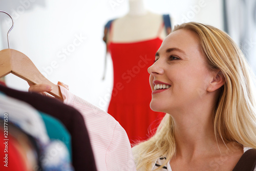 happy blond woman shopping for clothes in store