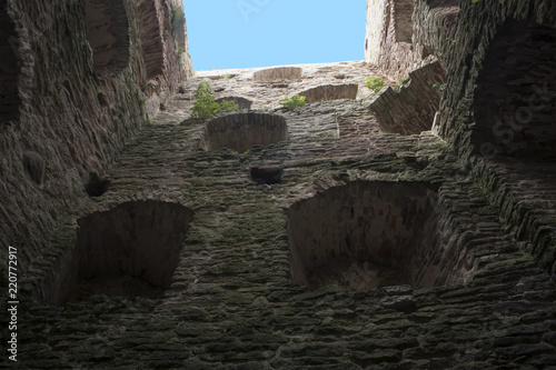 Inside view of ancient medieval fortress tower with open top, limestone walls with embrasures