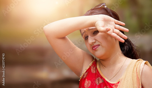 Canvas Print Woman suffers from heat of strong sunlight,Blur background
