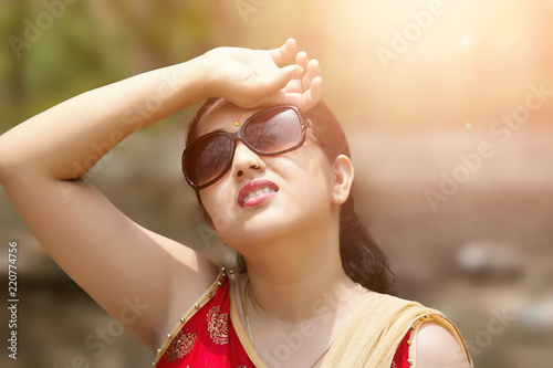 Woman suffers from heat of strong sunlight,Blur background