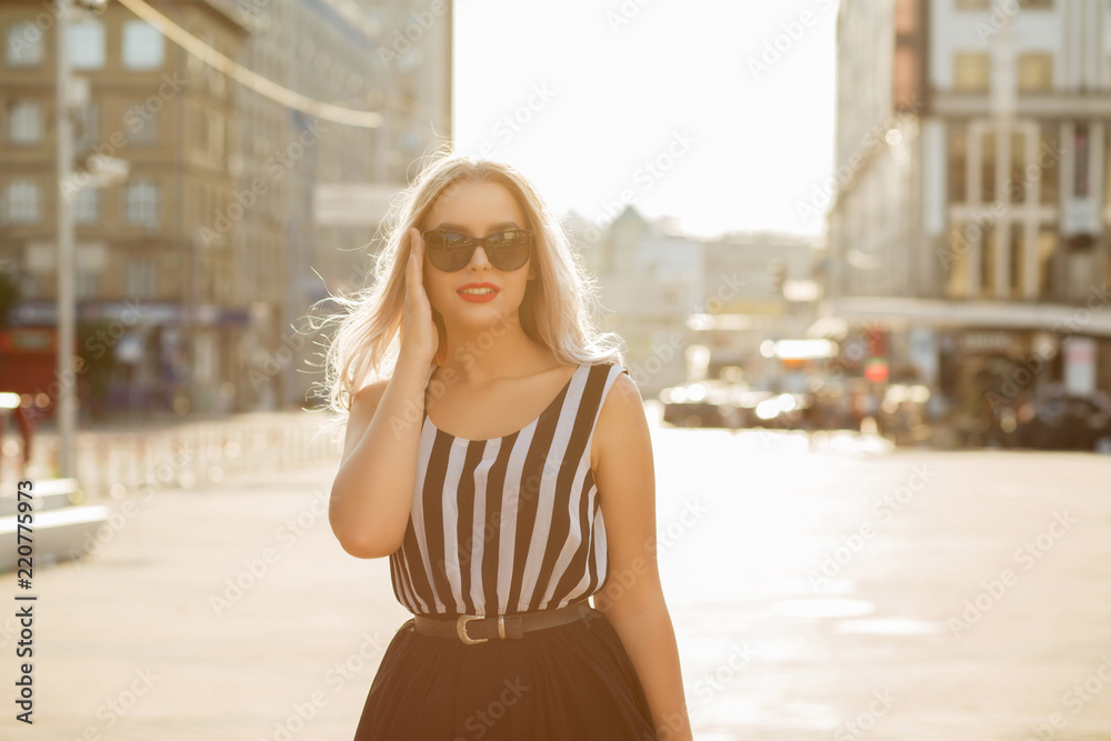 Street portrait of elegant cheerful girl in glasses enjoying summer day. Space for text