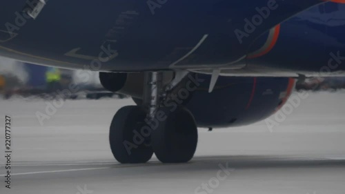 Landing gear of jet airliner taxiing at airport. Engine works and makes heat haze photo