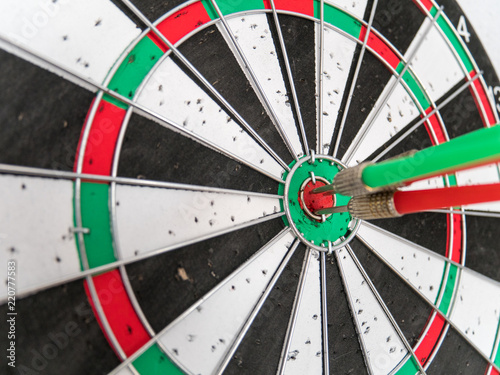 Close Up of Dart Holes on Dart Board Due to Throwing Darts Multiple Times. Four Darts Hit the Red Bullseye