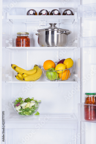 ripe fruits, salad, pan and preserved tomatoes in fridge
