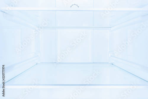shelves in empty open white fridge photo