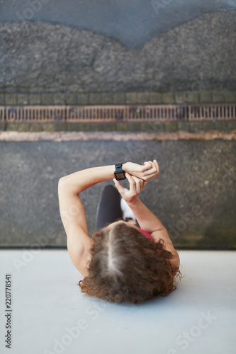 Frau kontrolliert Leistung mit dem Fitness Tracker photo