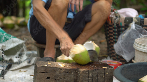 Man Hacking Fresh Coconut With Machete - Anonymous