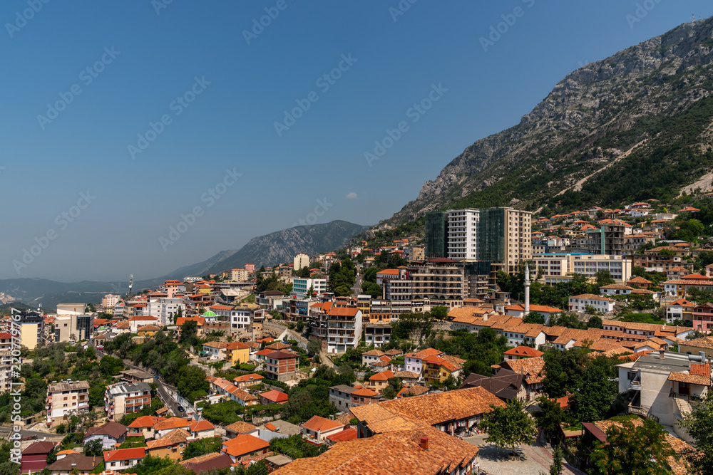 Scenic landscape view of the city Kruja on a mountain slope with blue sky in Albania.
