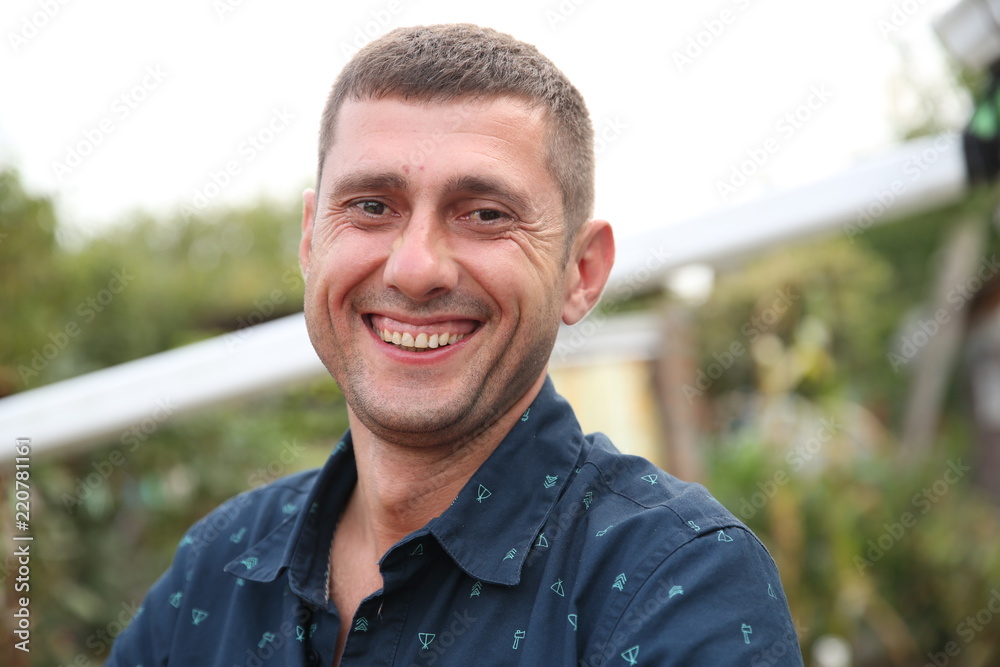 Young active white smiling man outdoors. Portrait in soft focus blur background. Young active white smiling man outdoors. Portrait in soft focus blur background.