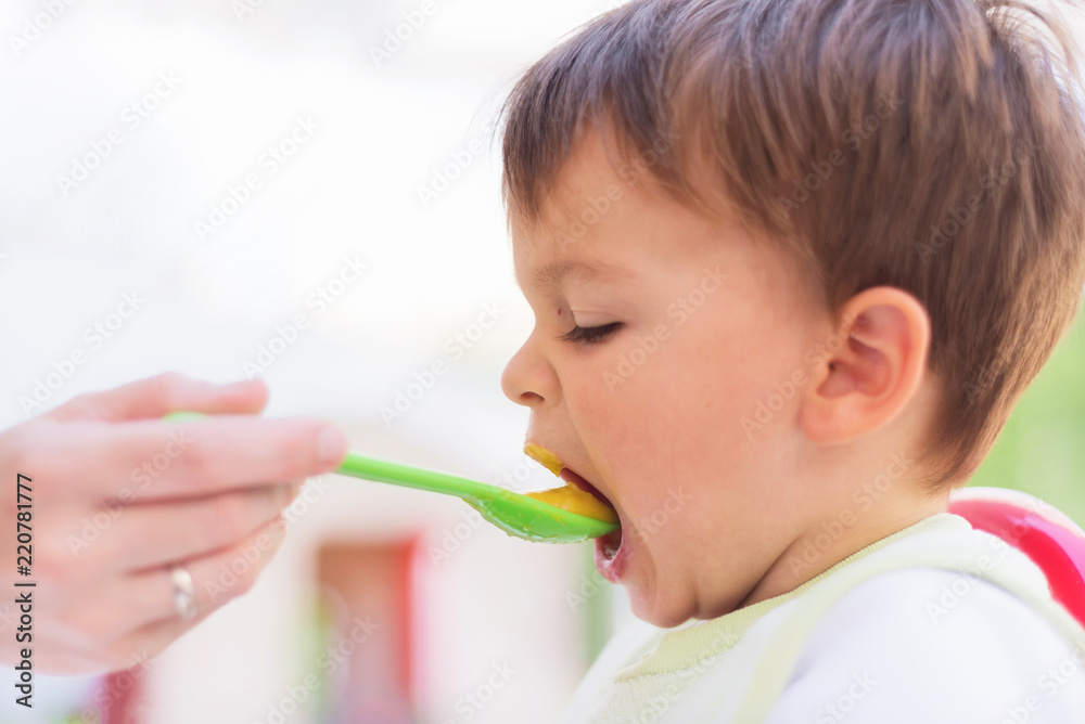 Baby eating the lunch while looking at the smartphone Baby eating the lunch while looking at the smartphone