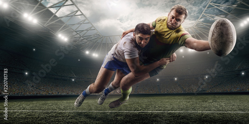 Canvas Print Two male Rugby players fight for the ball in flight on professional rugby stadiu